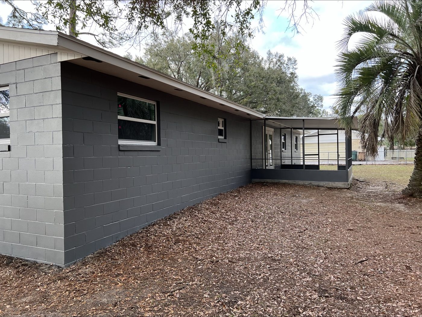 After: repainted side elevation in charcoal gray with new screened porch