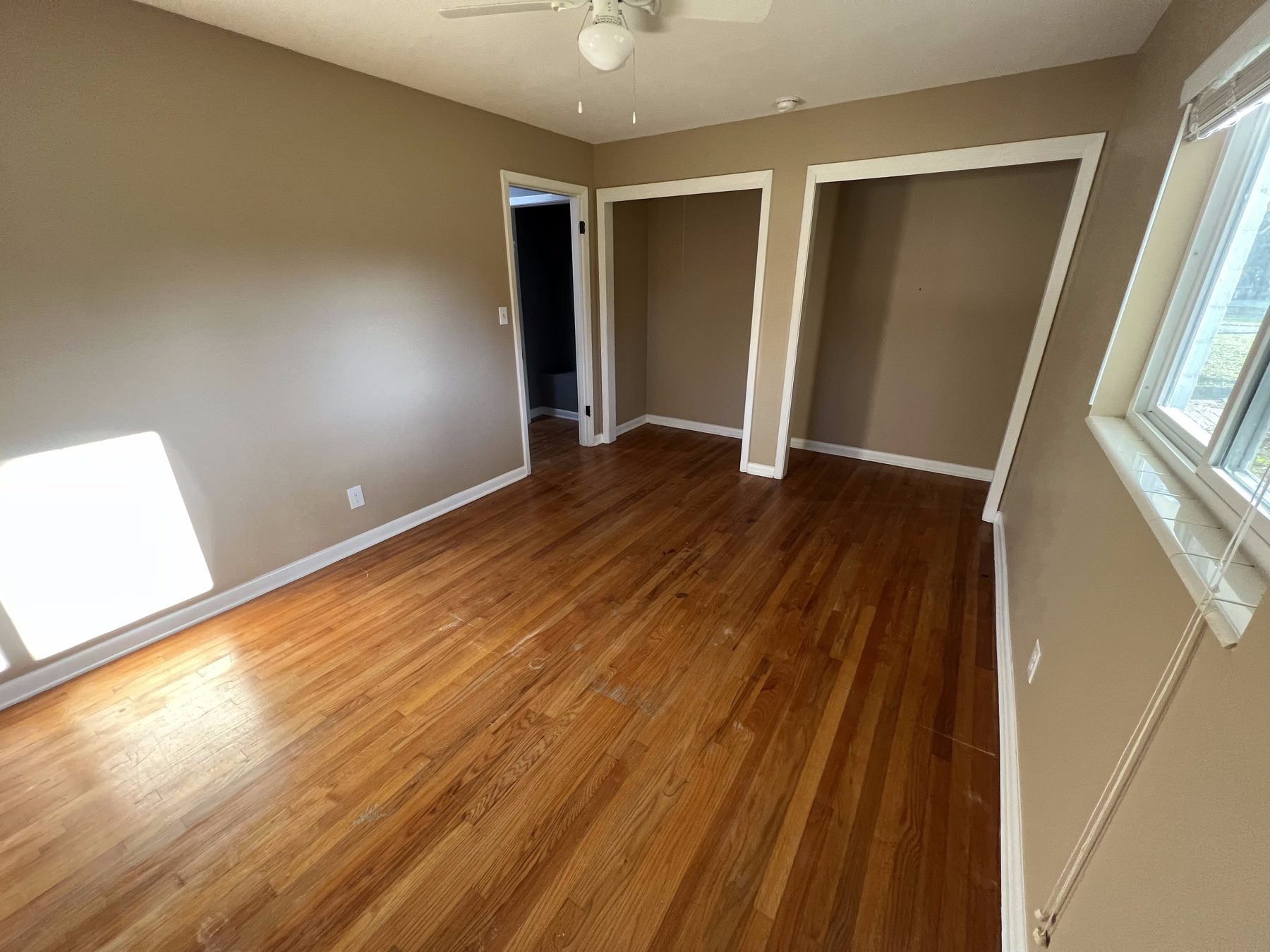 Freshly painted bedroom with closets and natural light