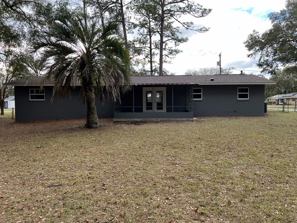 Freshly painted charcoal home exterior with a palm tree in the front yard