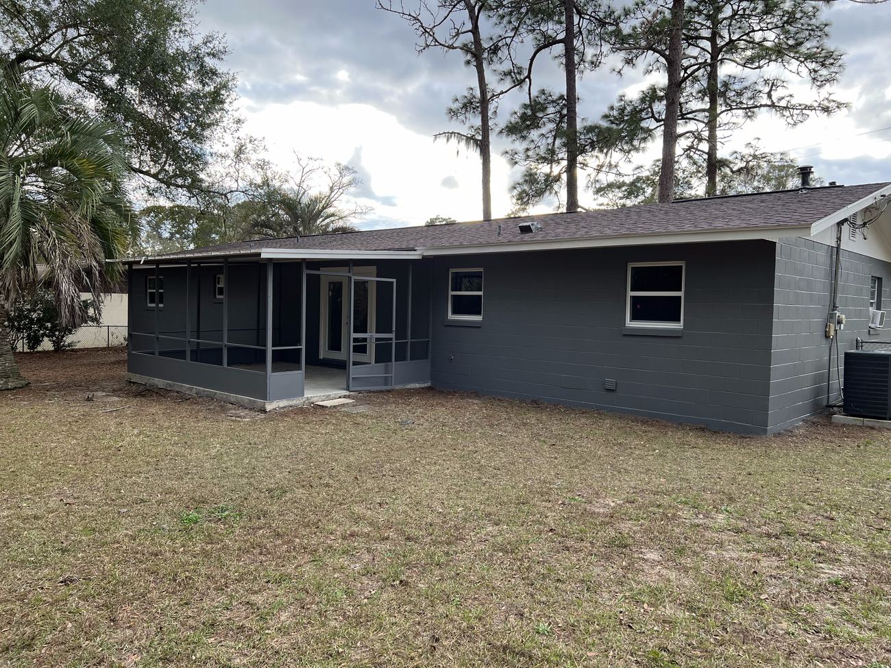 Freshly painted charcoal home exterior with screened porch