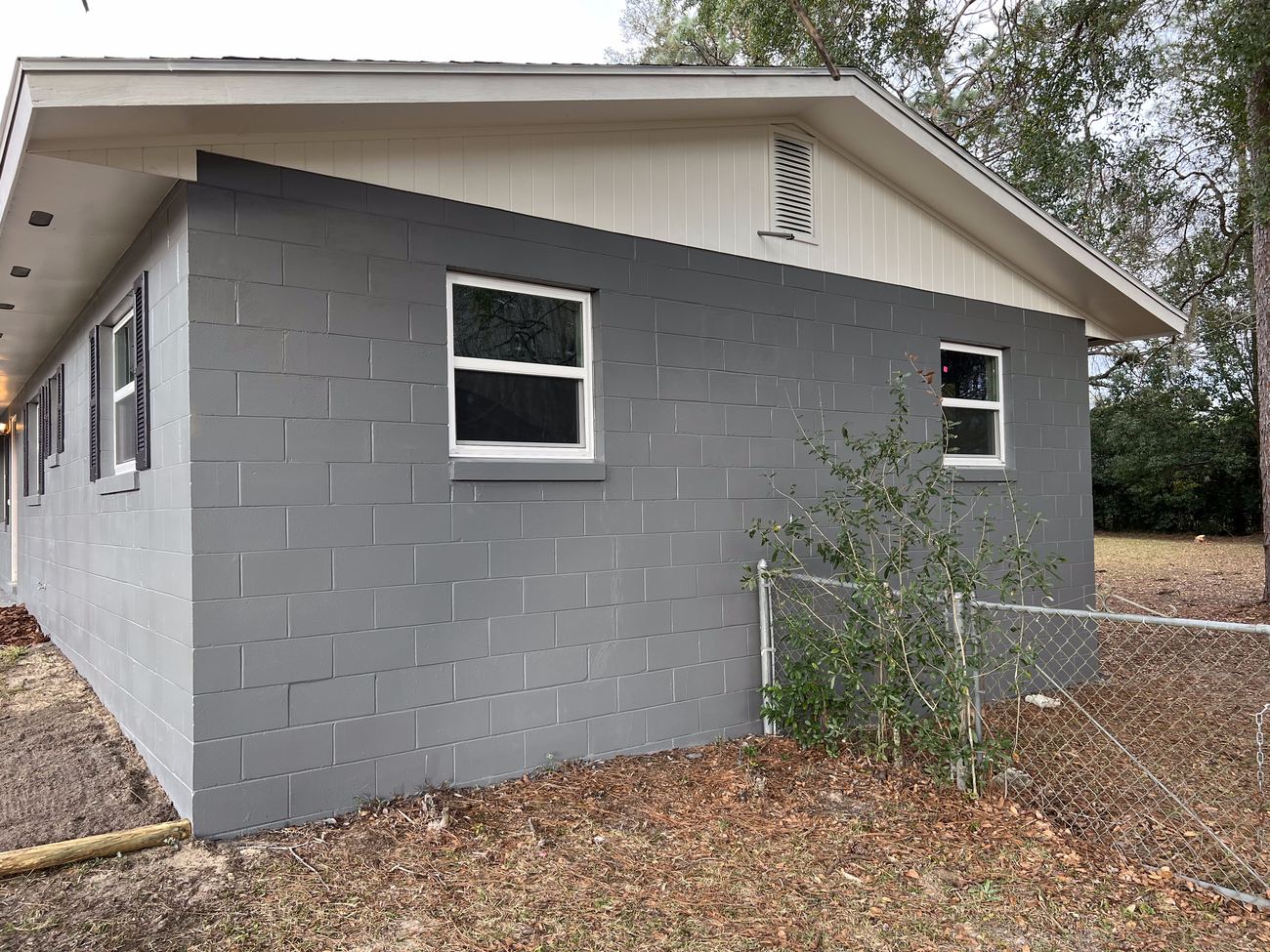 Corner view of a freshly painted gray block home exterior